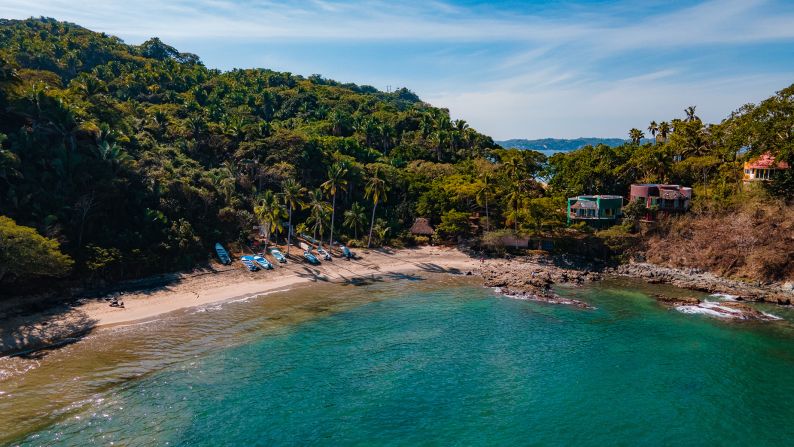 A small beach surrounded by tropical palm trees beckons in San Pancho.