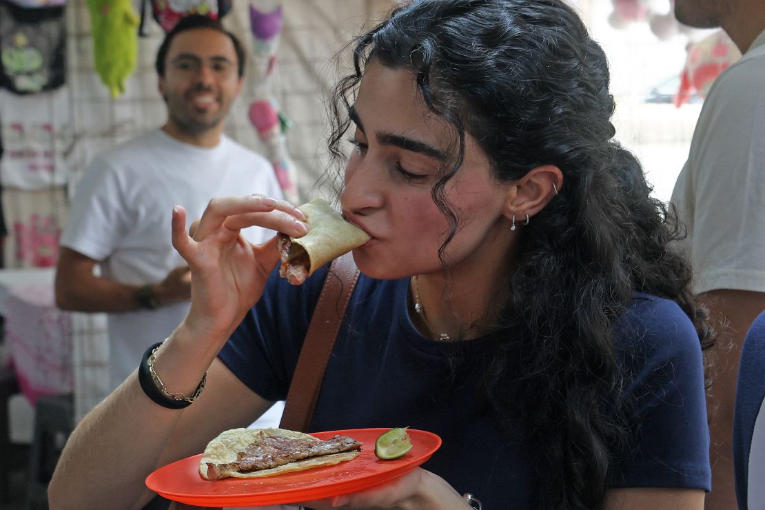 A diner tucks into one of popular tacos at the no frills eatery in Mexico City.