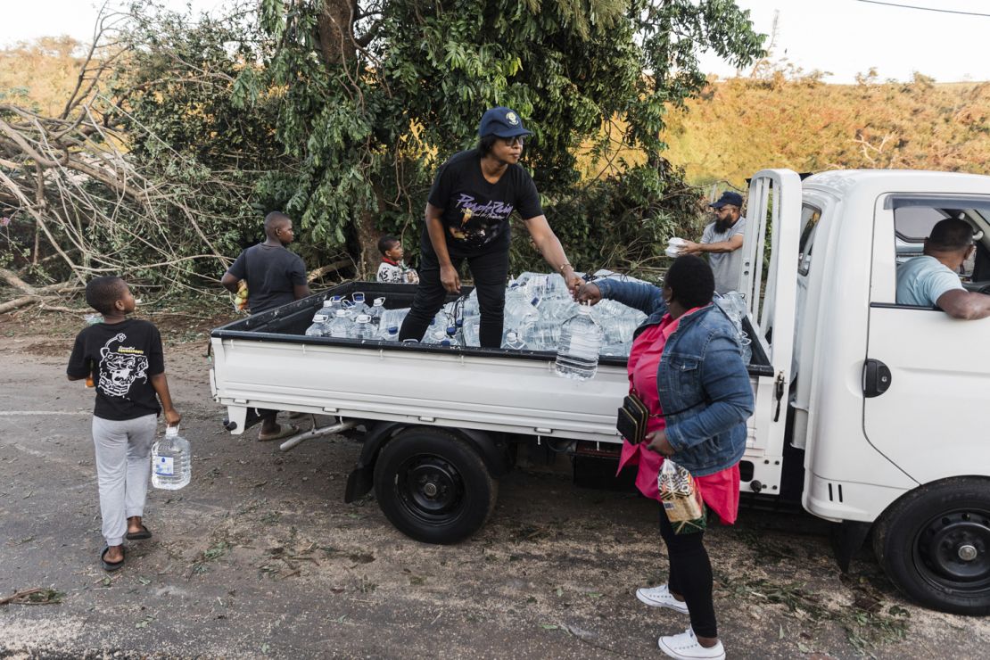 Volunteers hand out water to residents whoses homes were destroyed after a tornado and extreme weather struck at an informal settlement in Tongaat, north of Durban, on June 04, 2024.