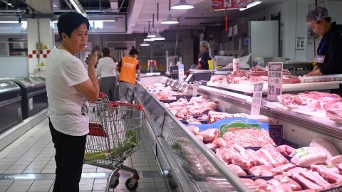 A customer selects pork products at a supermarket in Beijing in June 2024.