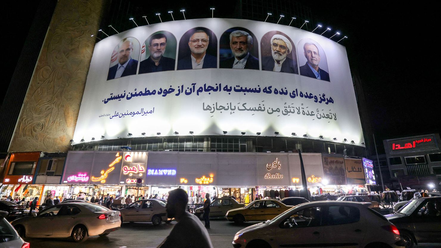 Vehicles move past a billboard displaying the faces of the six candidates running in the Iranian presidential election, in Valiasr Square, central Tehran, Iran on June 17.