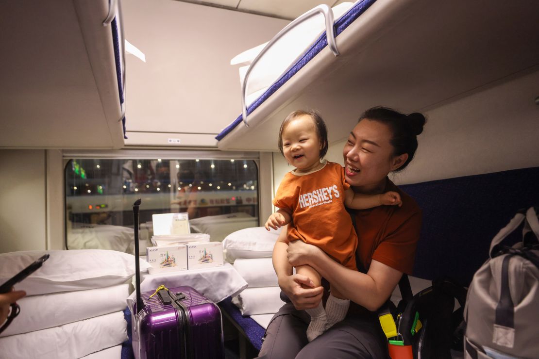 A passenger with a child boards the high-speed sleeper train in Beijing for its inaugural journey to Hong Kong's West Kowloon Station.