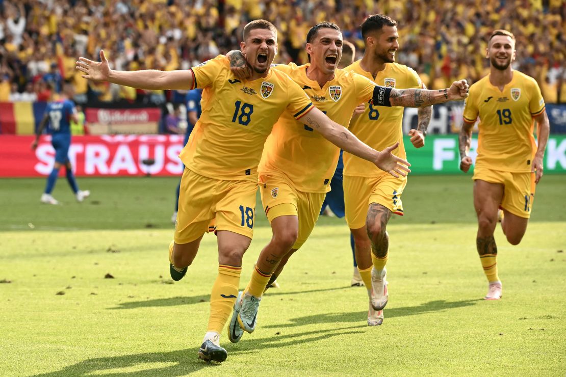 Romanian midfielder Razvan Marin (L) celebrates scoring his team's first goal from the penalty spot during the Euro 2024 Group E football match against Slovakia at the Frankfurt Arena in Frankfurt am Main on June 26, 2024.