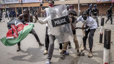 Protesters use a Kenya Police anti-riot shield to protect themselves from tear gas canisters and rubber bullets amid clashes during demonstrations in downtown Nairobi, on July 2, 2024.