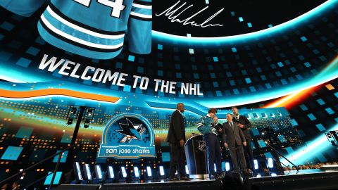 LAS VEGAS, NEVADA - JUNE 28: Macklin Celebrini puts on a jersey onstage after being selected first overall by the San Jose Sharks during the first round of the 2024 Upper Deck NHL Draft at Sphere on June 28, 2024 in Las Vegas, Nevada. (Photo by Dave Sandford/NHLI via Getty Images)