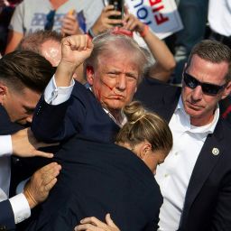 TOPSHOT - Republican candidate Donald Trump is seen with blood on his face surrounded by secret service agents as he is taken off the stage at a campaign event at Butler Farm Show Inc. in Butler, Pennsylvania, July 13, 2024. Donald Trump was hit in the ear in an apparent assassination attempt by a gunman at a campaign rally on Saturday, in a chaotic and shocking incident that will fuel fears of instability ahead of the 2024 US presidential election.
The 78-year-old former president was rushed off stage with blood smeared across his face after the shooting in Butler, Pennsylvania, while the gunman and a bystander were killed and two spectators critically injured. (Photo by Rebecca DROKE / AFP) (Photo by REBECCA DROKE/AFP via Getty Images)