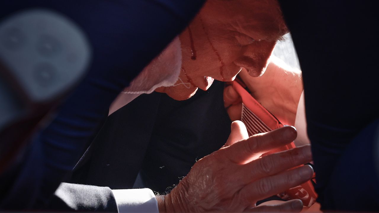 Former President Donald Trump is shown covered by Secret Service agents after an incident during a rally on July 13, 2024, in Butler, Pennsylvania.