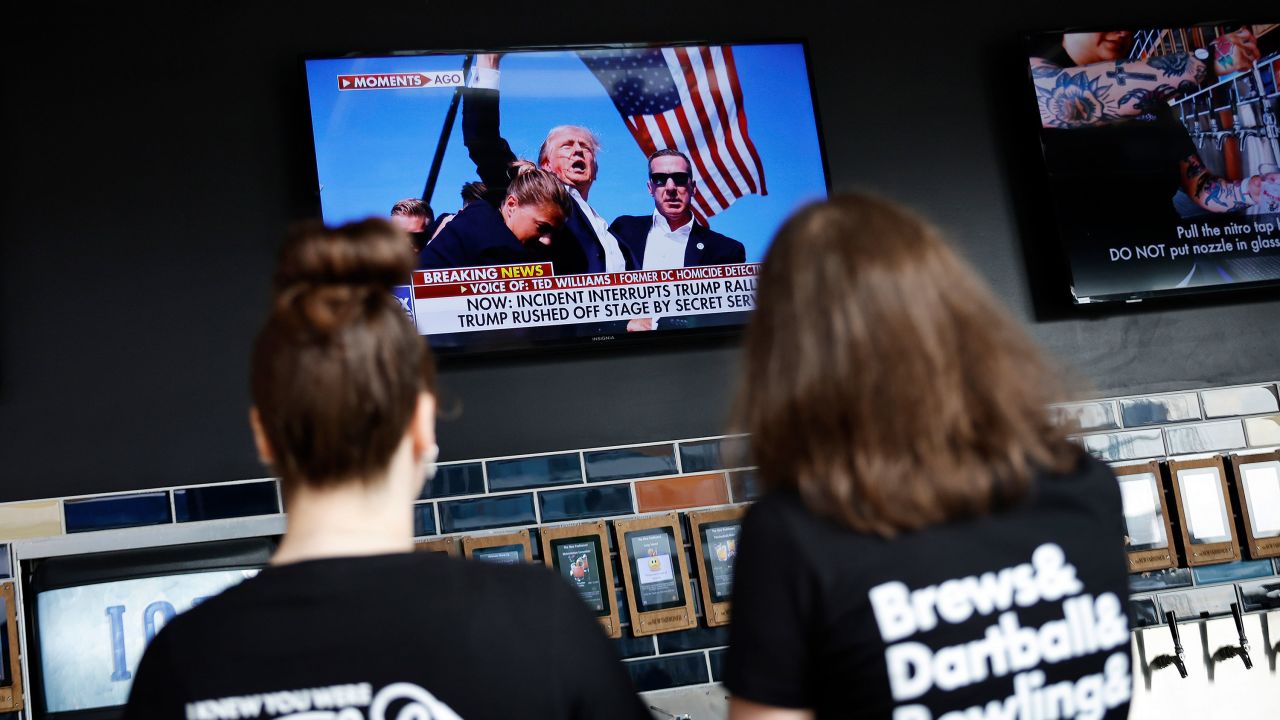 People look at images of an injured former U.S. President and Republican presidential nominee Donald Trump.