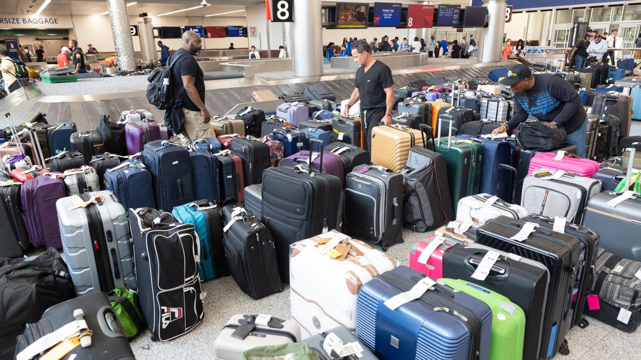 Delta passengers try to find their bags after cancelled and delayed flights at Hartsfield-Jackson Atlanta International Airport on July 22 in Atlanta.