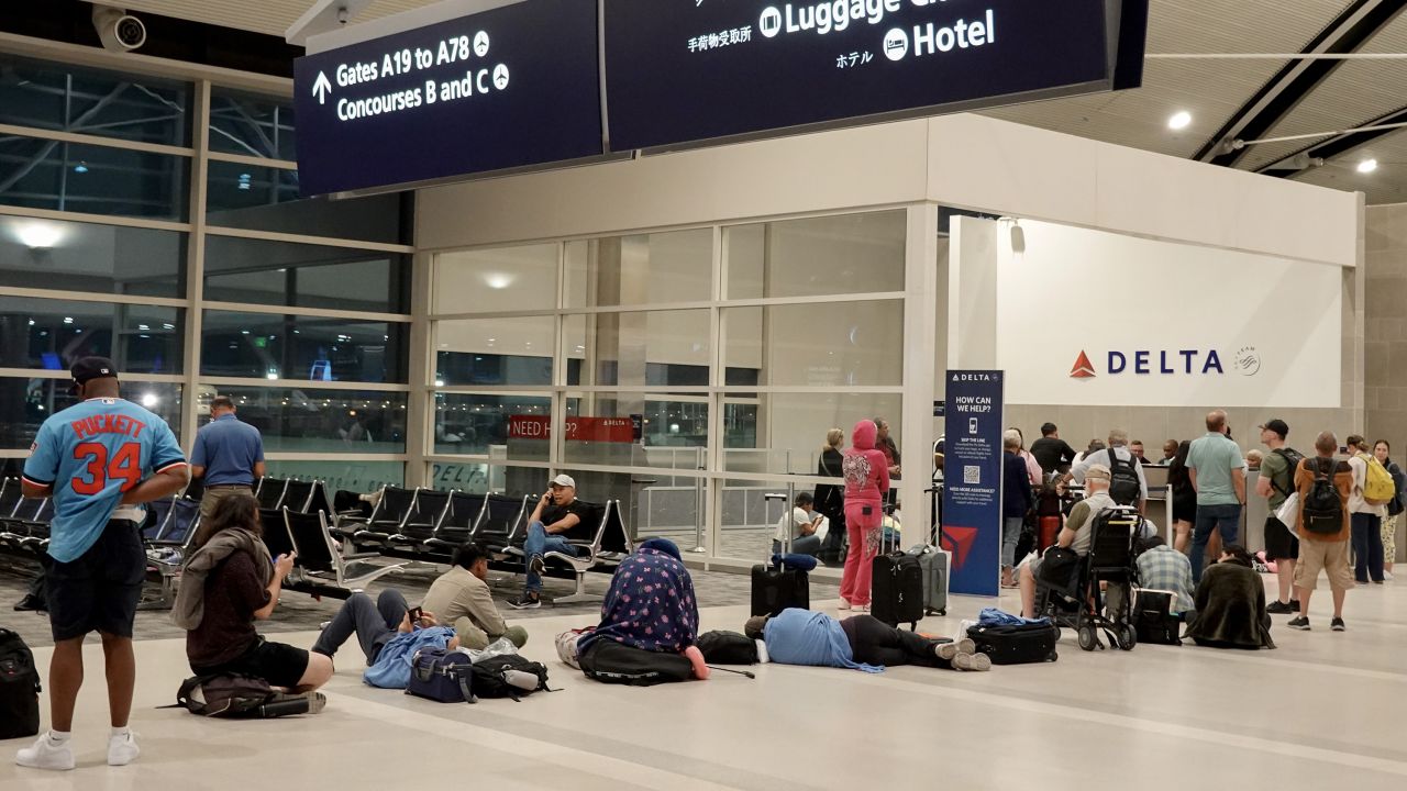 Travelers wait in a long line to speak with a Delta representative at the help desk in the McNamara terminal at the Detroit Metropolitan Wayne County Airport on July 20, 2024, in Detroit, Michigan.