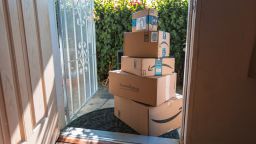 A photo of a stack of Amazon boxes outside of a house