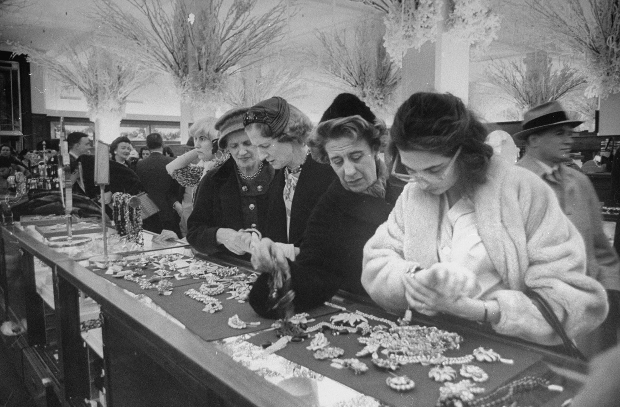 Shoppers browse pieces on sale in the jewelry department store of Saks Fifth Avenue in New York City in November 1960.