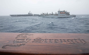 USNS Alan Shepard (T-AKE 3), front, and USS Theodore Roosevelt (CVN 71) sail alongside USS Russell (DDG 59) during a vertical replenishment.