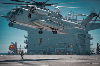 Marines fast-rope from a CH-53E Super Stallion helicopter aboard USS Miguel Keith (ESB 5) in the Philippine Sea.