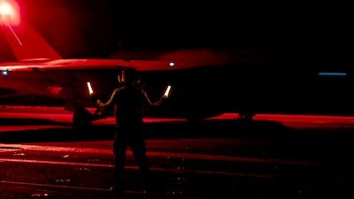 ABH3 Daluis Rodriguez guides an F/A-18E Super Hornet from VFA-136 aboard USS Harry S. Truman (CVN 75).