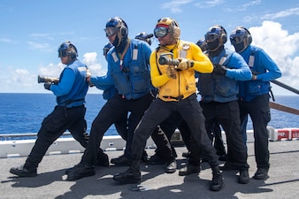 Sailors engage a simulated fire during a mass casualty drill aboard USS Boxer (LHD 4) in the Pacific Ocean.