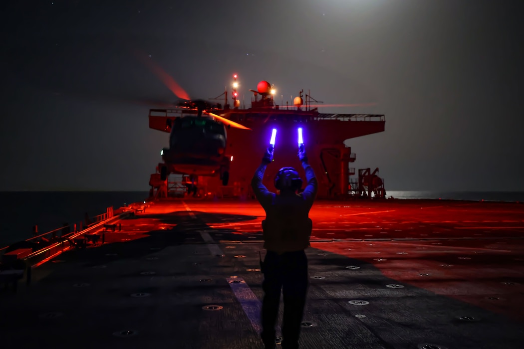 ABH2 Culver directs an SH-60R Sea Hawk helicopter for take-off from USS Hershel "Woody" Williams (ESB 4) during operations in the Atlantic Ocean.