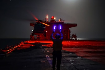 ABH2 Culver directs an SH-60R Sea Hawk helicopter for take-off from USS Hershel "Woody" Williams (ESB 4) during operations in the Atlantic Ocean.