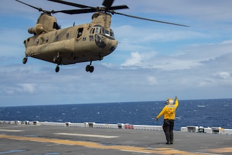 A U.S. Army CH-47 Chinook helicopter takes off from USS Tripoli (LHA 7) in the Pacific Ocean.