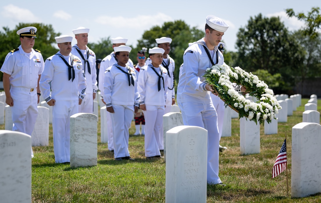 Sailors from PCU) John F. Kennedy (CVN 79) place a wreath at the grave of a PT-109 survivor at Arlington National Cemetery.