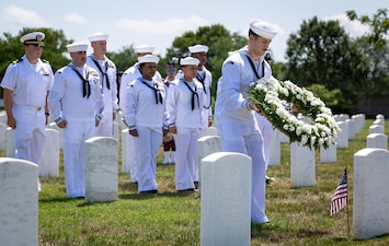 Sailors from PCU) John F. Kennedy (CVN 79) place a wreath at the grave of a PT-109 survivor at Arlington National Cemetery.