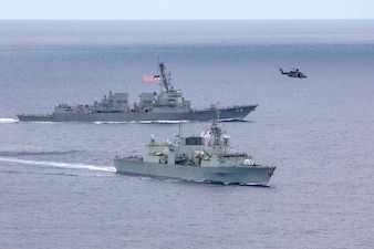USS Ralph Johnson (DDG 114), left, transits the South China Sea with the Royal Canadian Navy.
