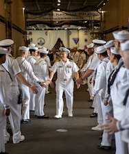 Capt. Dave Pollard shakes hands with Sailors as he departs after a change of command ceremony aboard the USS George H.W. Bush (CVN 77) at Norfolk Naval Shipyard in Portsmouth, Va.