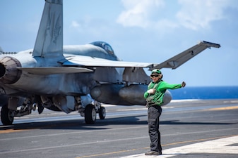 ABE Carnell Hill signals the retraction of the arresting gear wire after an F/A-18E Super Hornet from VFA-195 makes an arrested landing aboard the USS Ronald Reagan (CVN 76) during flight operations in the Pacific Ocean.