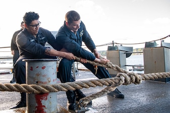 Sailors handle mooring lines aboard USS Nimitz (CVN 68).