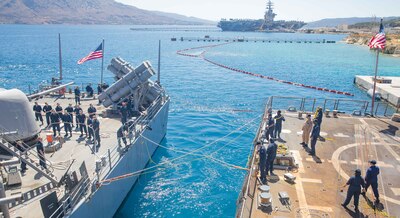 Sailors aboard USS Philippine Sea (CG 58), left, and USS Gravely (DDG 107) handle mooring lines as the Philippine Sea nests along the starboard side of Gravely in Souda Bay.