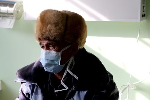 A TB patient is being consulted by the doctors. Patients and doctors are both required to wear mask within the building.