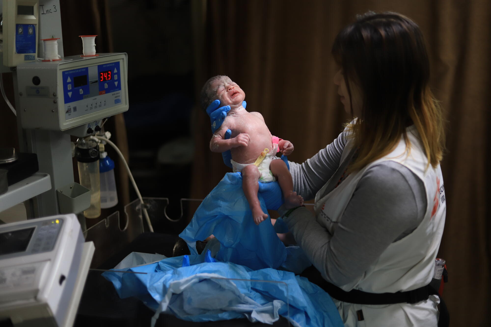 MSF midwife Hin So checks on a newborn baby at Nasser Hospital in southern Gaza