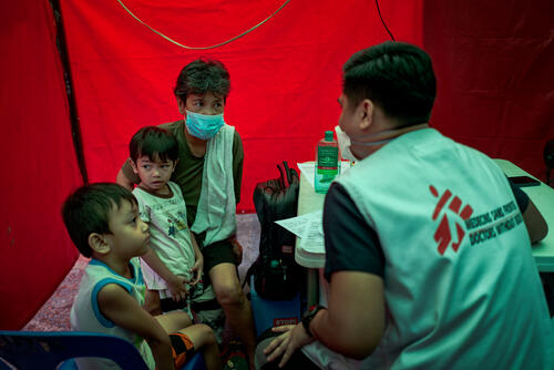 MSF medical staff speak to Agustina and her grandsons at a TB 'case finding' site in Manila, Philippines