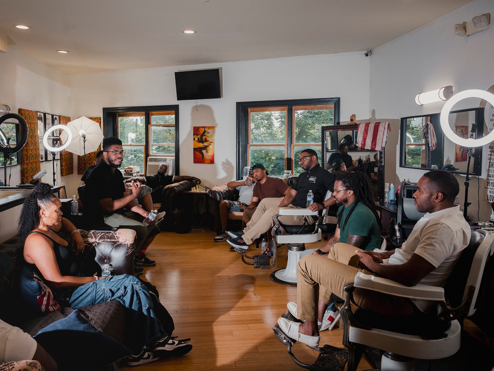 A group of people sitting in a Philadelphia barbershop having a discussion.