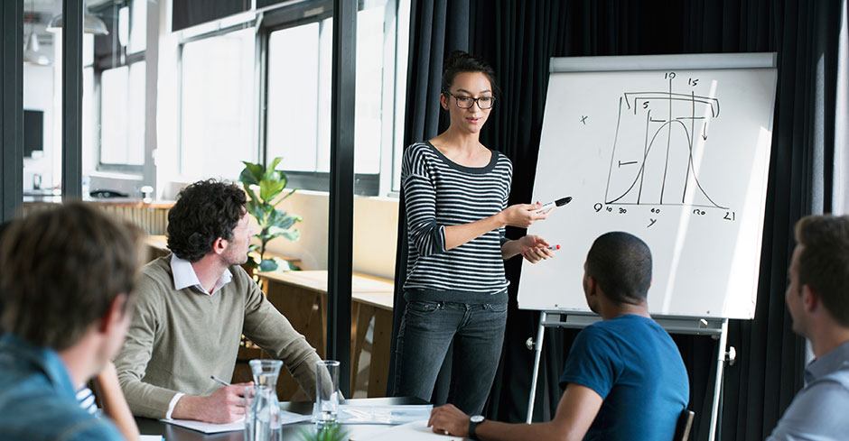 Woman explains statistical data to male colleagues in conference room