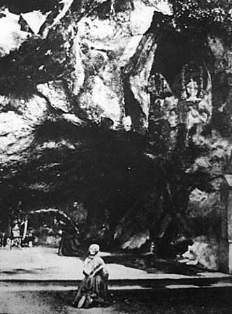 Foto av Bernadette Soubirous i Lourdes-grotten i 1863, fem år etter de første åpenbaringene.