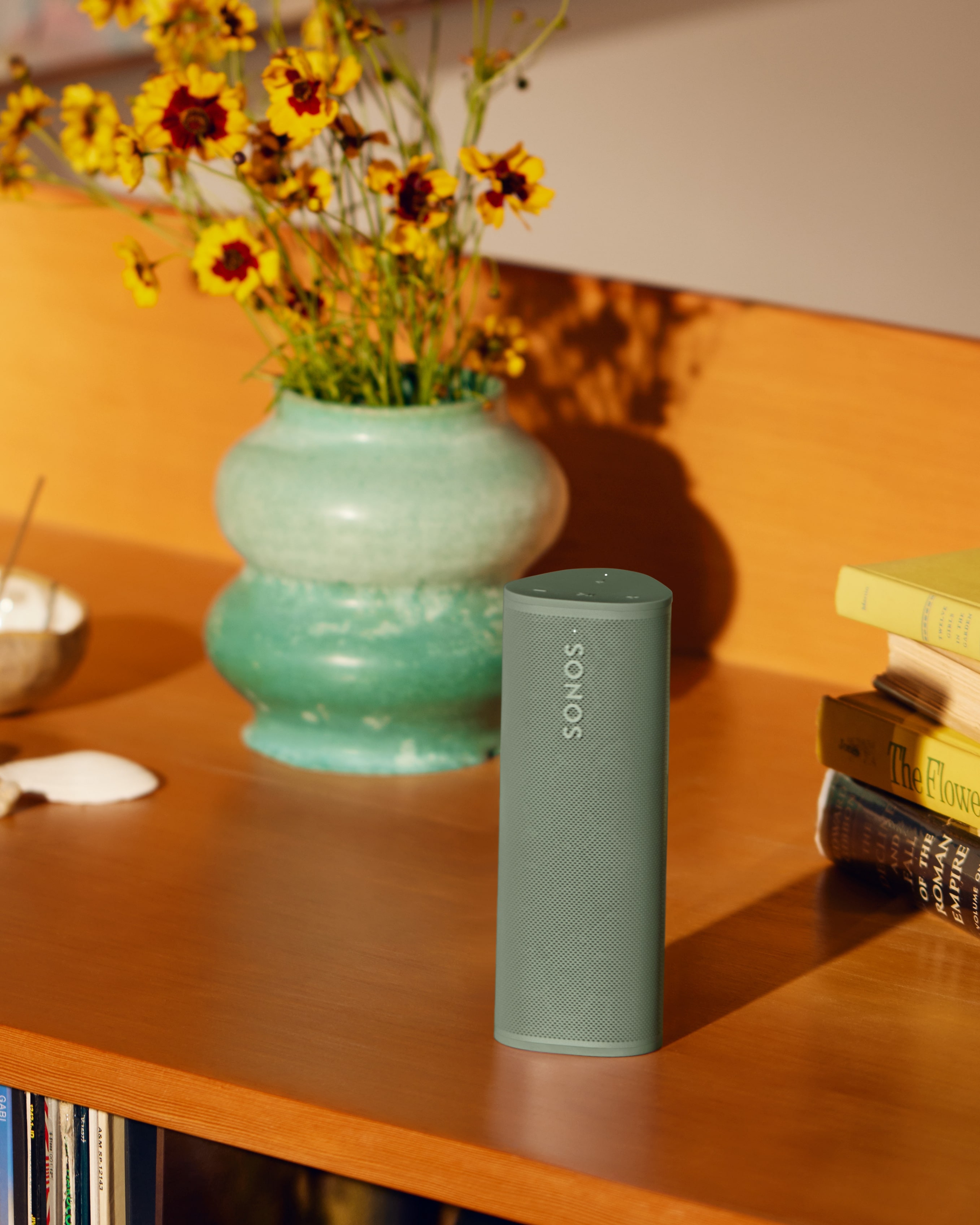 Sonos Roam 2 Olive on a credenza next to vase with flowers