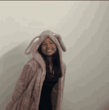 a girl wearing a bunny hooded jacket smiles at the camera