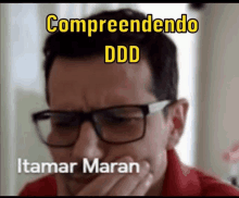 a man wearing glasses is covering his mouth with his hand and the words comprendendo ddd itamar maran are above him