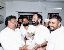 a man with a beard is holding a bouquet of flowers in his hands