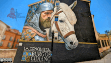 a painting of a man and a horse on the side of a building that says la conquista