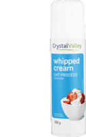 a bottle of crystal valley whipped cream with strawberries in a bowl