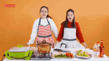 two women standing next to each other in front of a table with a pot on it and the word channel on the bottom