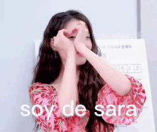 a woman making a heart with her hands and the words soy de sara written below her