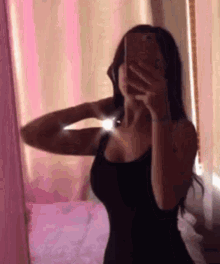 a woman is taking a picture of herself in a mirror .