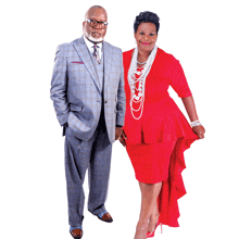 a man in a suit and tie and a woman in a red dress are standing next to each other