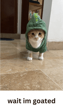 a cat wearing a green dinosaur costume is standing on a tile floor