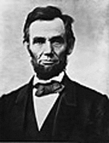 abraham lincoln is wearing a suit and tie and has a beard .