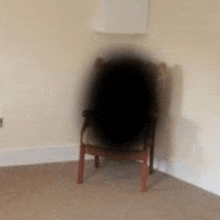 a chair is sitting in a corner of a room with a shadow on it .