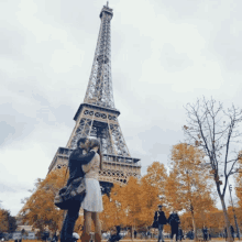 a couple kissing in front of the eiffel tower in paris